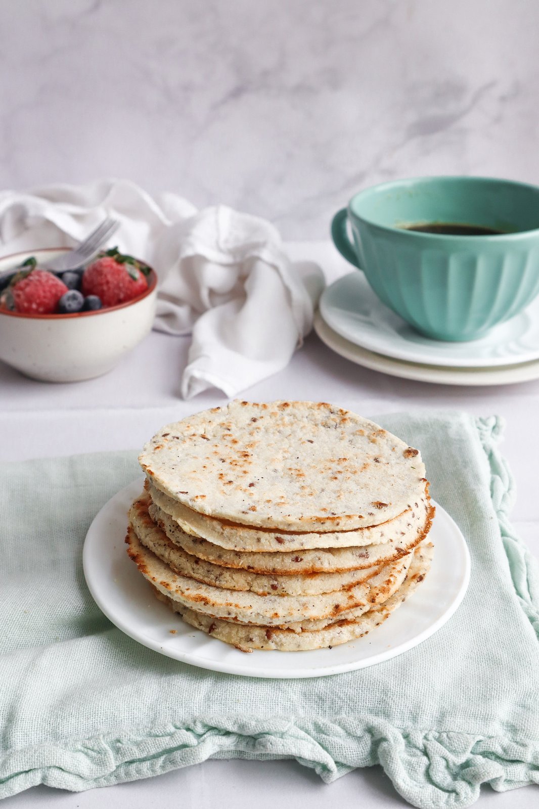 Arepas de harina de coco con semillas asadas servidas con queso fresco encima