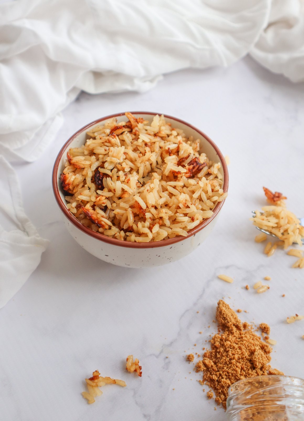 Detalle del arroz con coco mostrando granos sueltos y titote tostado