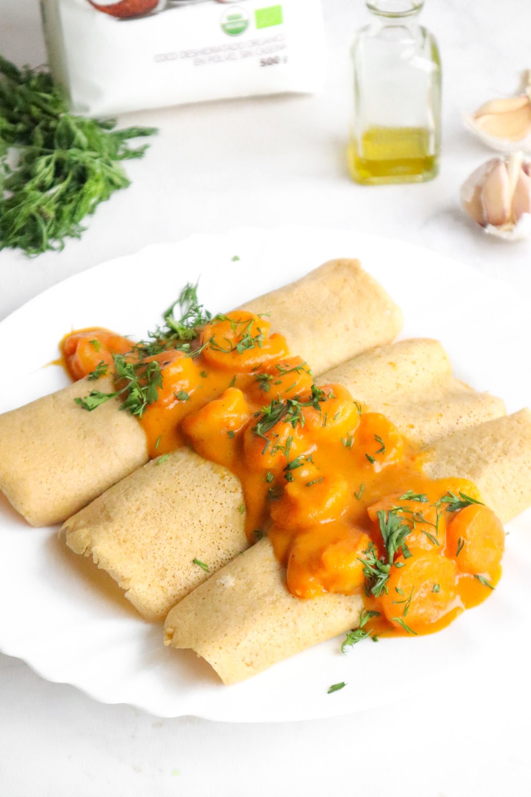 Crepes dorados rellenos de camarones al curry con salsa cremosa de coco
