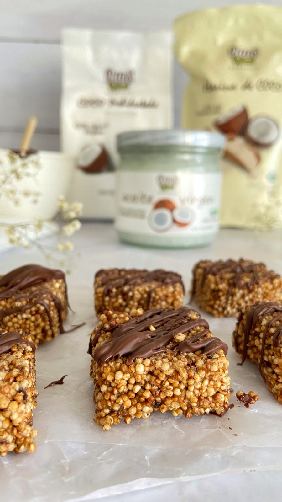 Cuadrados de amaranto y coco con baño de chocolate sobre tabla de madera