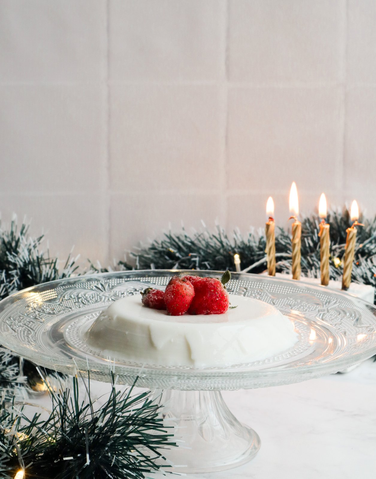 Natilla de coco firme decorada con fruta fresca y coco rallado en plato blanco