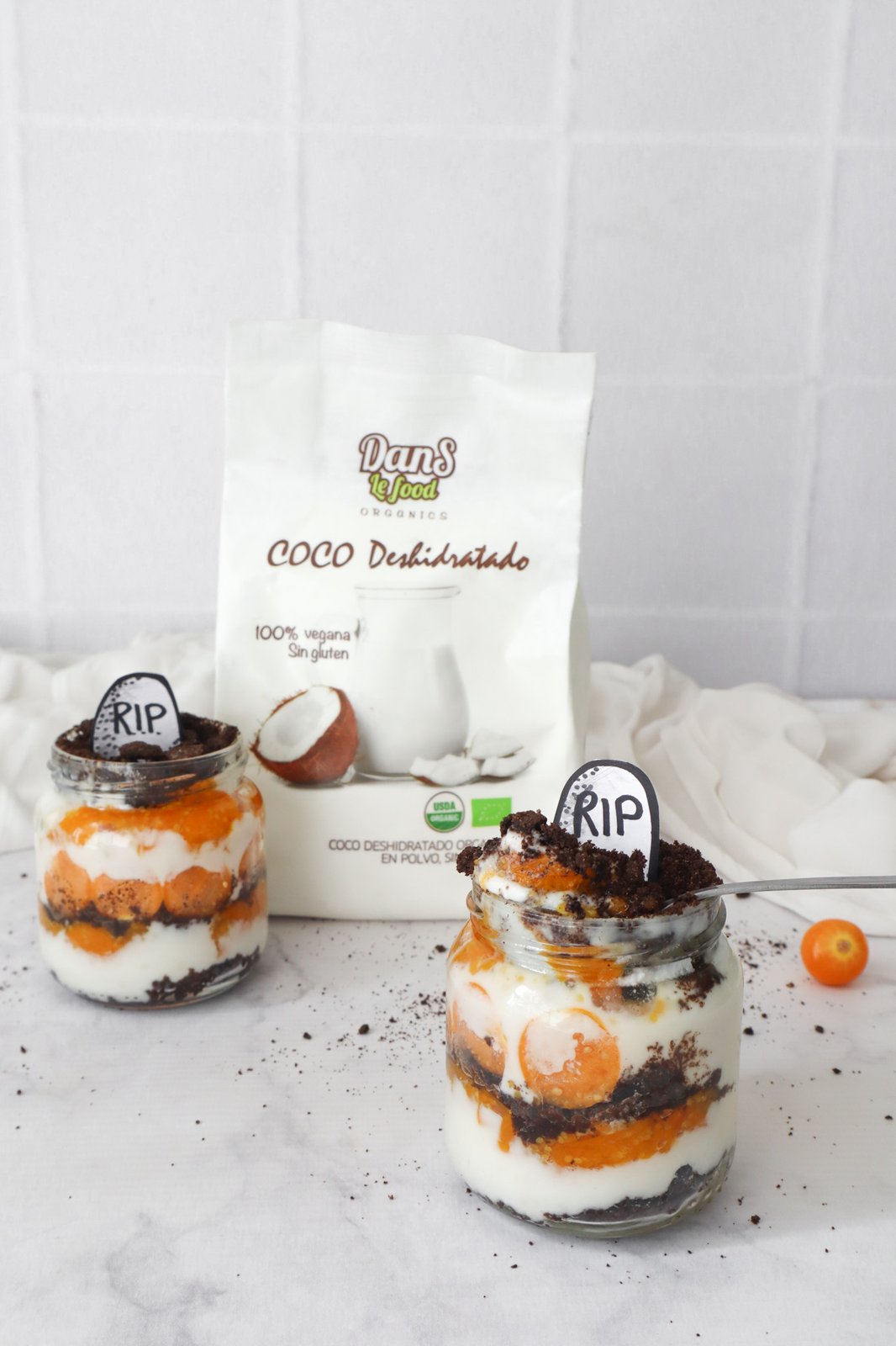 Trifle en jar de vidrio con capas de tierra de Oreo, crema de coco y mermelada de uchuva