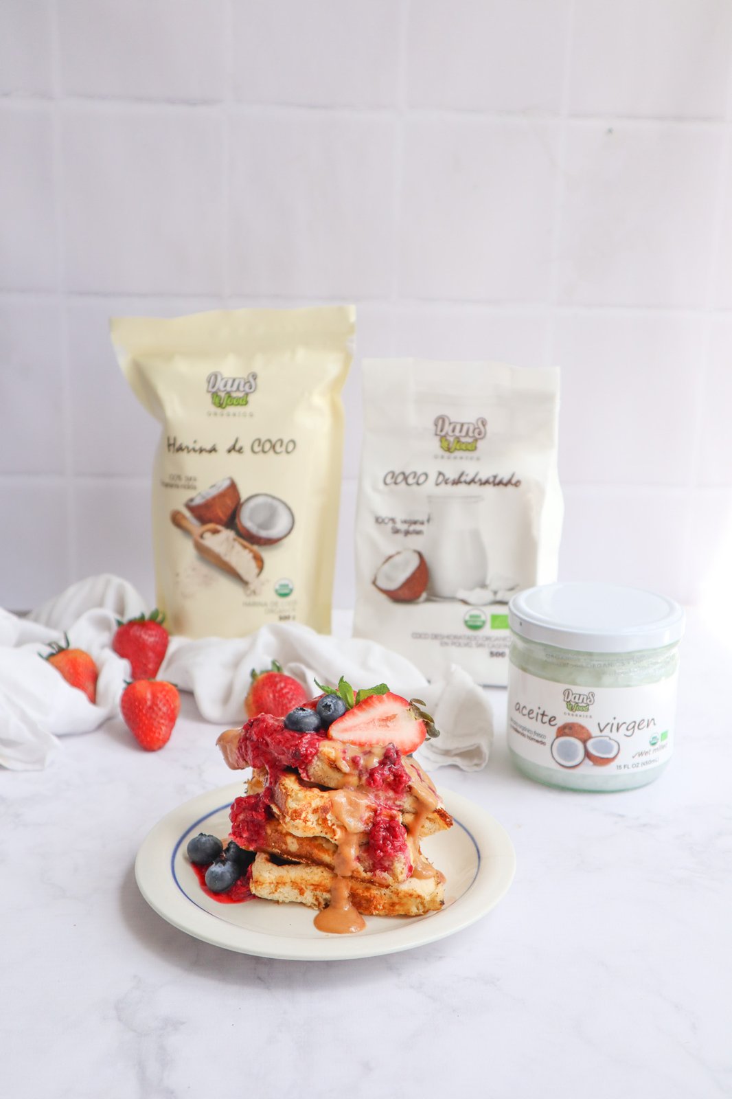 Waffles de coco servidos junto a la harina de coco, coco deshidratado y aceite de coco virgen Danslefood Organics